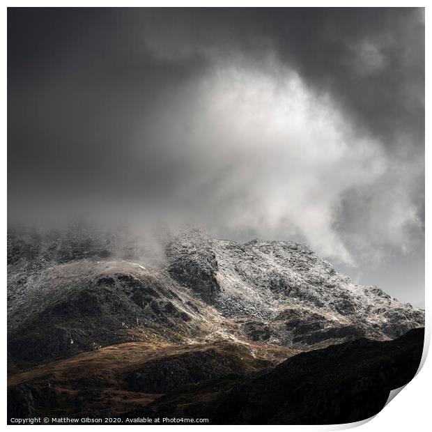 Stunning moody dramatic Winter landscape image of snowcapped Tryfan mountain in Snowdonia with stormy weather brooding overhead Print by Matthew Gibson