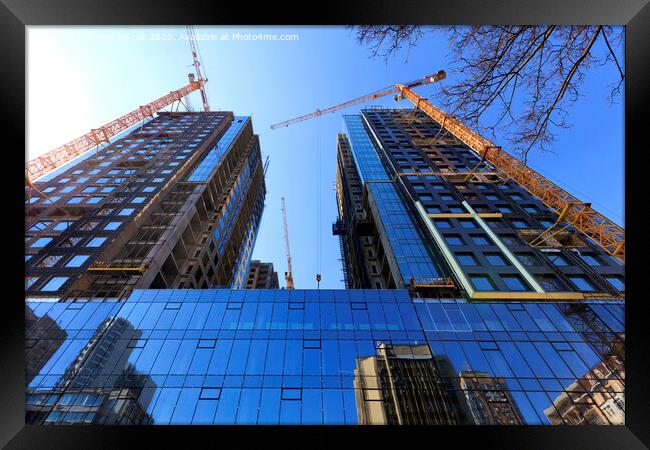 The glass facade, a reflection of the blue sky and cranes near a modern concrete building under construction. Framed Print by Sergii Petruk