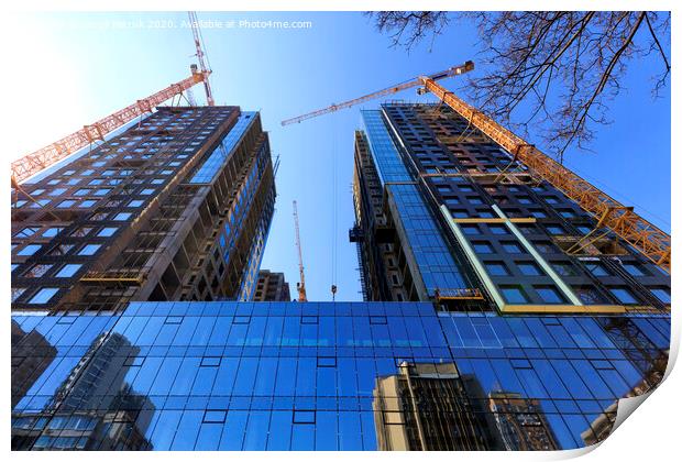 The glass facade, a reflection of the blue sky and cranes near a modern concrete building under construction. Print by Sergii Petruk