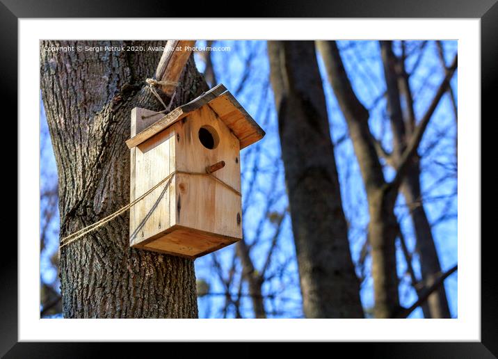 A new nesting box is attached with a rope high on a tree trunk in a spring park. Framed Mounted Print by Sergii Petruk
