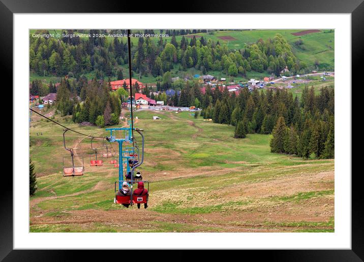 Mountain lift carries people into the valley to the village and the foot of the mountain. Framed Mounted Print by Sergii Petruk