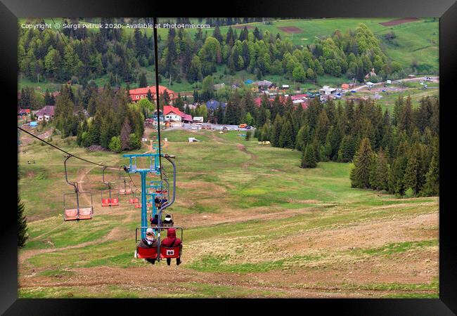 Mountain lift carries people into the valley to the village and the foot of the mountain. Framed Print by Sergii Petruk