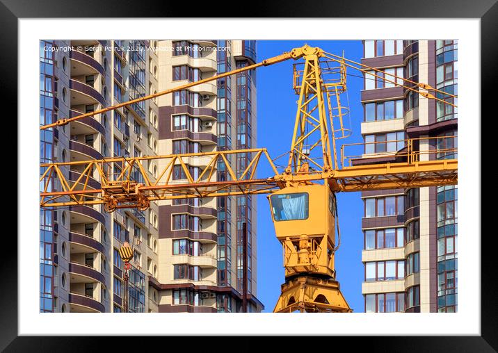 Crane between the facades and near the modern residential building under construction. Framed Mounted Print by Sergii Petruk