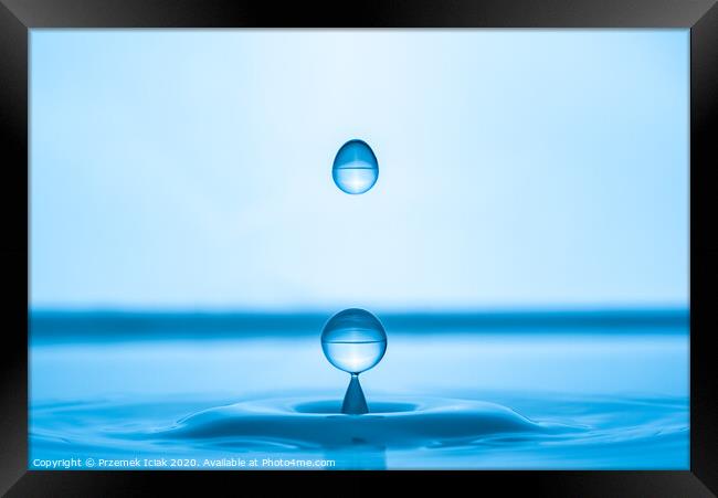 Water drop splashing into blue water surface Framed Print by Przemek Iciak