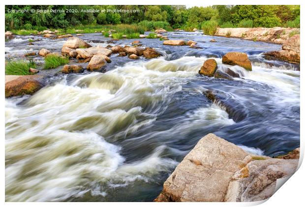 The rapid flow of the river in the blur, rocky shores, boulders and rapids, bright green vegetation on the other side of the shore. Print by Sergii Petruk