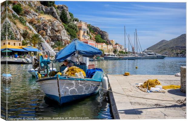 Fisherman repairing nets at Symi harbour. Canvas Print by Chris North