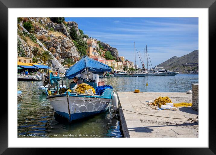 Fisherman repairing nets at Symi harbour. Framed Mounted Print by Chris North