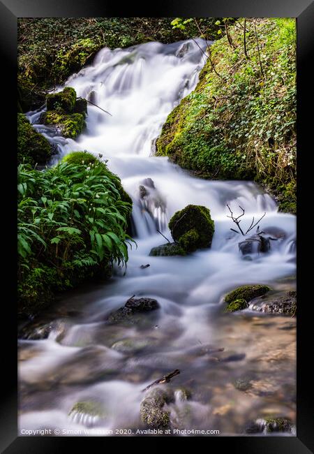 A waterfall surrounded by trees Framed Print by Simon Wilkinson