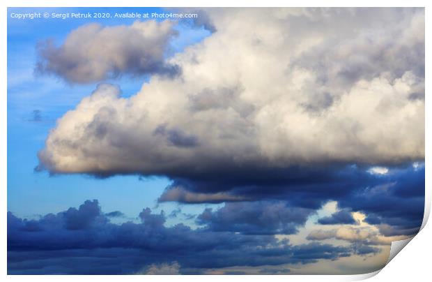 Storm clouds gather in a pile closing off a blue sky Print by Sergii Petruk