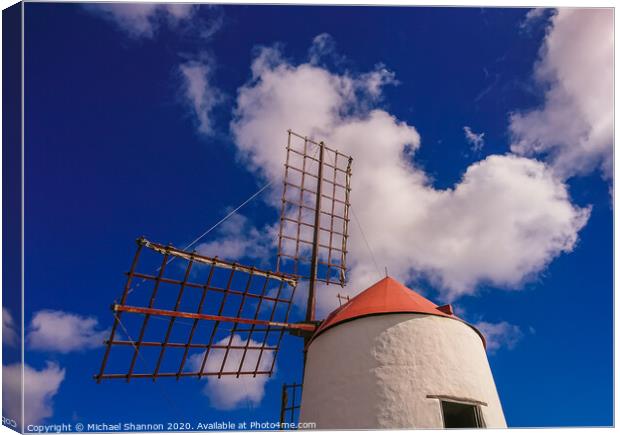 Windmill and sails on a sunny day in Lanzarote, Ca Canvas Print by Michael Shannon