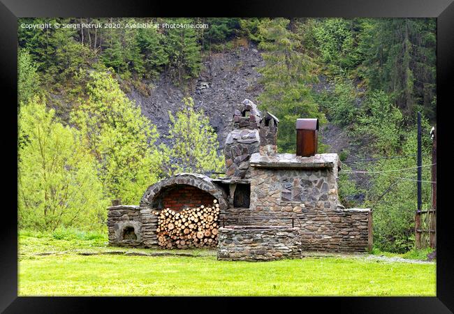 Old stone stove with firewood and smokehouse in the mountains of the Carpathians. Framed Print by Sergii Petruk