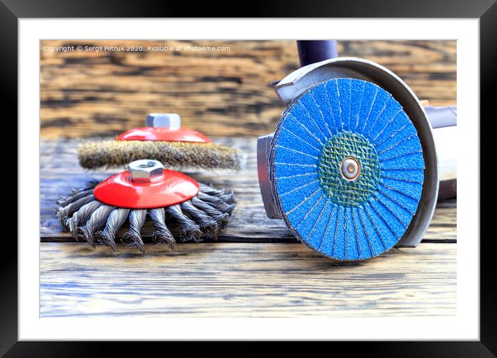 Angle grinder with grinding disc brushes lies on the background of a wooden table. Framed Mounted Print by Sergii Petruk