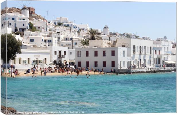 Tourists relaxing on the beach in Chora, Mykonos,  Canvas Print by Kevin Hellon