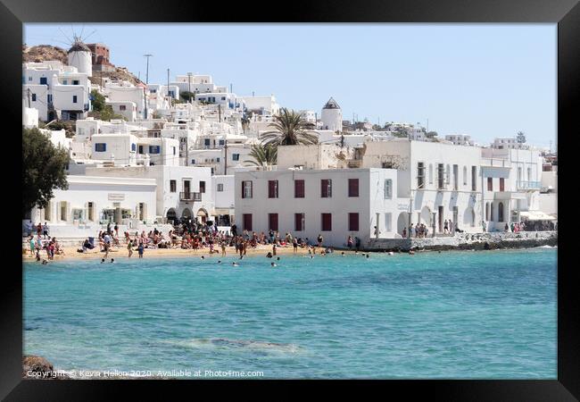 Tourists relaxing on the beach in Chora, Mykonos,  Framed Print by Kevin Hellon
