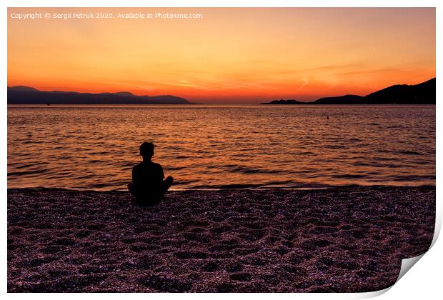 Silhouette of a teenager sitting on the seashore and watching a beautiful, bright sunset on the Gulf of Corinth. Print by Sergii Petruk
