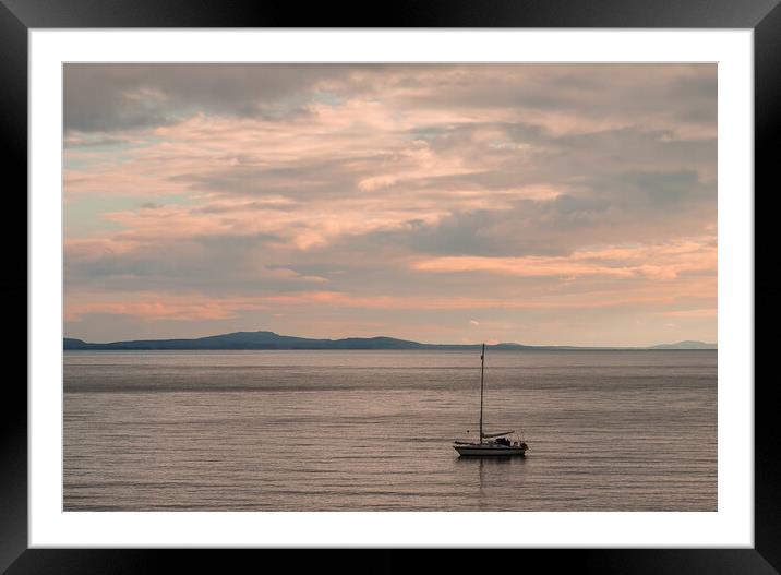 Sailboat moored off the coast at Aberffraw. Framed Mounted Print by Colin Allen