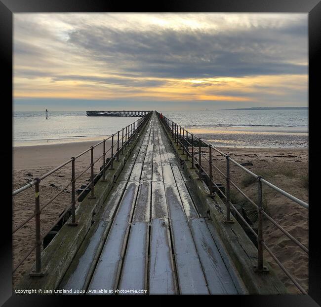 A pier heading out to sea Framed Print by Iain Cridland