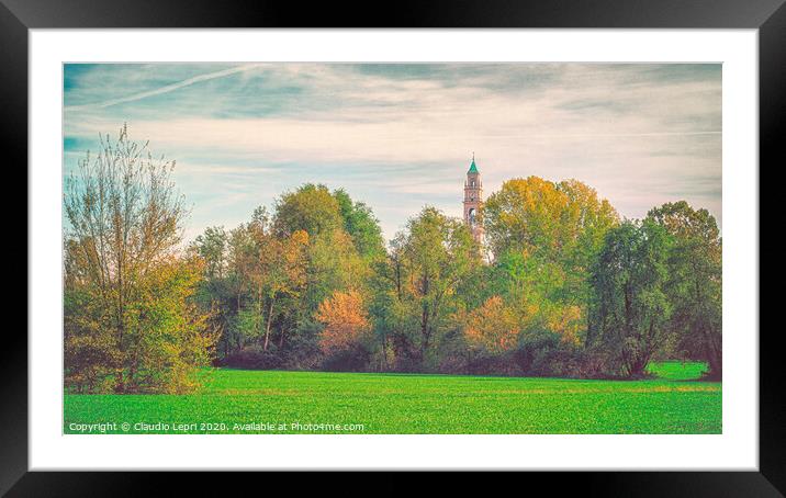 Large green field with trees and one bell tower. Framed Mounted Print by Claudio Lepri