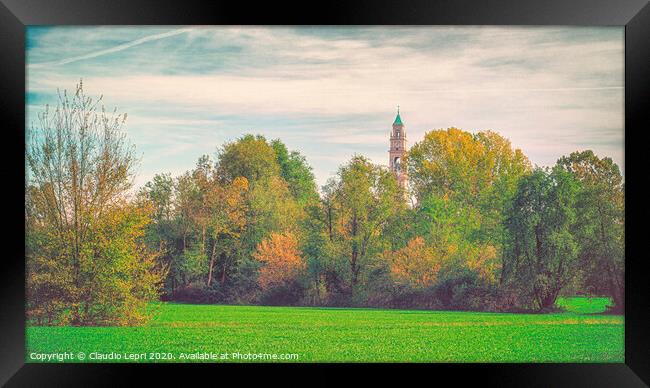 Large green field with trees and one bell tower. Framed Print by Claudio Lepri