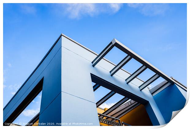 Roof of a blue painted straight design building behind a clear and clear sky at sunset. Print by Joaquin Corbalan