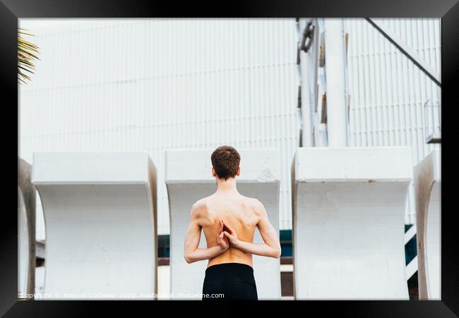 Young male athlete performing stretching exercises for back and arms in an urban place. Framed Print by Joaquin Corbalan