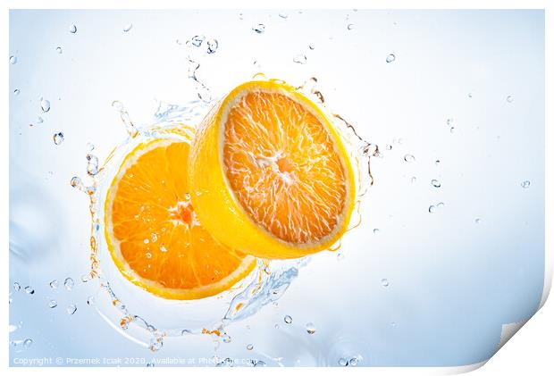 Two halves of orange fruit splashing into clear water. Print by Przemek Iciak