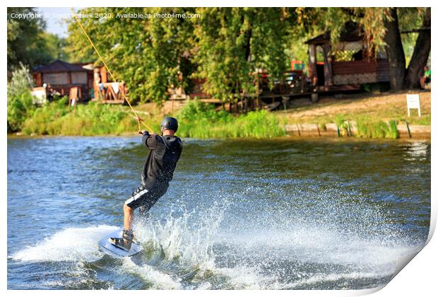 A wakeboarder rushes through the water at high speed along the green bank of the river. Print by Sergii Petruk