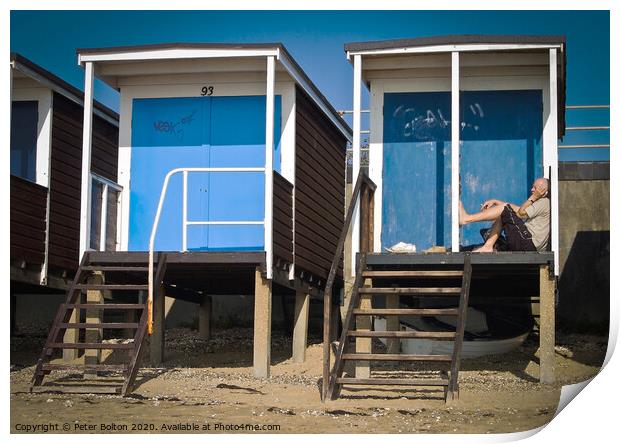 Beach huts at Thorpe Bay, Essex, with a person sitting on the floor talking on the phone. Print by Peter Bolton