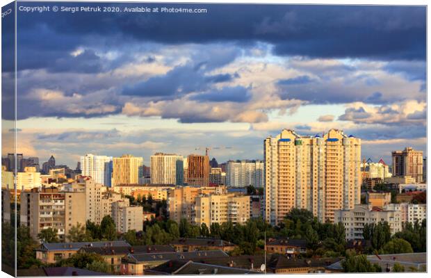 The beautiful light of the setting sun falls on the houses in the city landscape. Canvas Print by Sergii Petruk