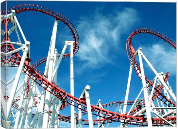 Roller coaster loops against a blue sky at Ingoldmells in Skegness. Canvas Print by john hill