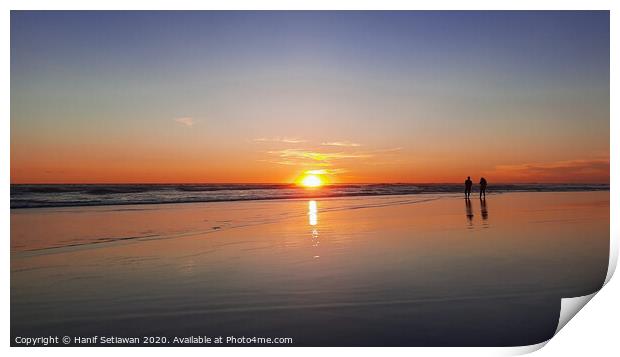 Silhouetted couple enjoys sunset at beach 1 Print by Hanif Setiawan