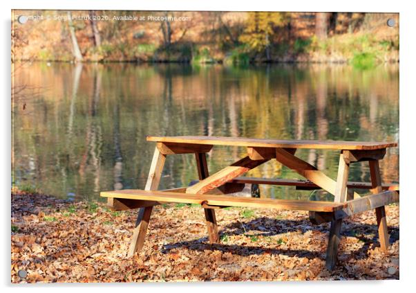 Wooden table with picnic benches in the open air on the background of fallen oak leaves near a forest lake. Acrylic by Sergii Petruk