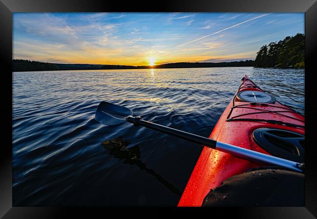 red plastic kayak on calm water in the sunset Framed Print by Jonas Rönnbro