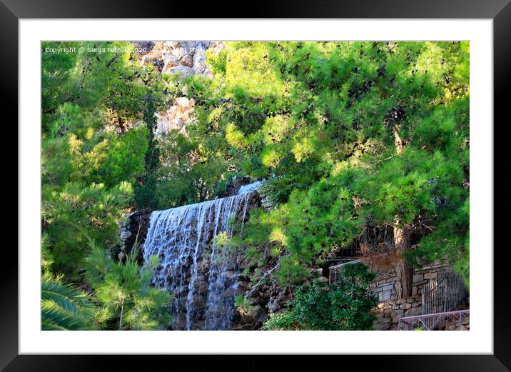 A large waterfall with radon water among boulders and thickets of spruce at the foot of a mountain in Loutraki, Greece. Framed Mounted Print by Sergii Petruk
