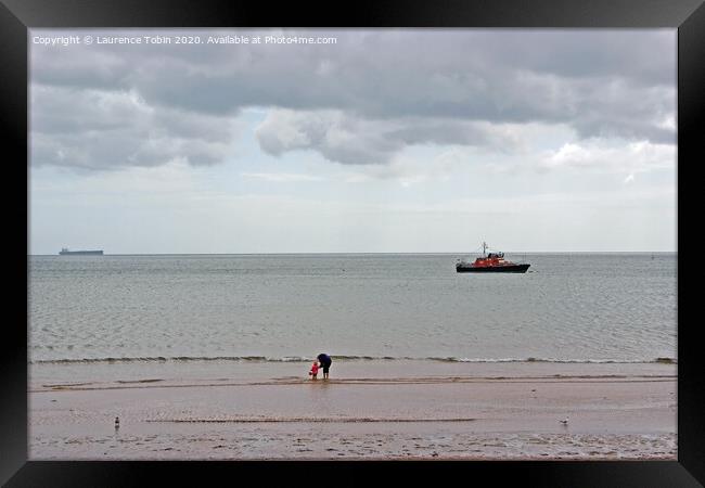 Paddling at low tide near Clacton, Essex Framed Print by Laurence Tobin
