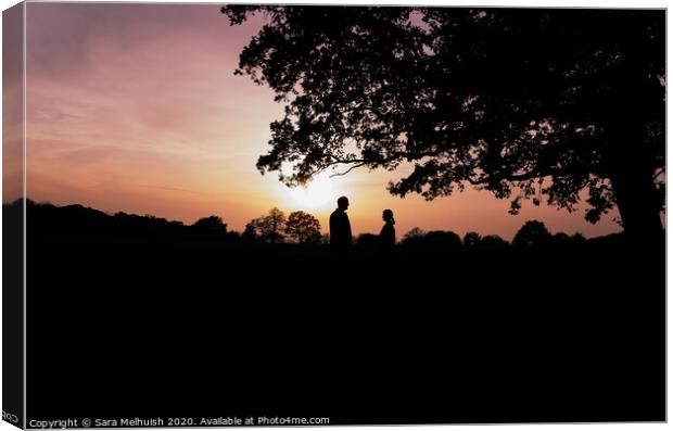 Two people standing under a tree in front of a sunset Canvas Print by Sara Melhuish