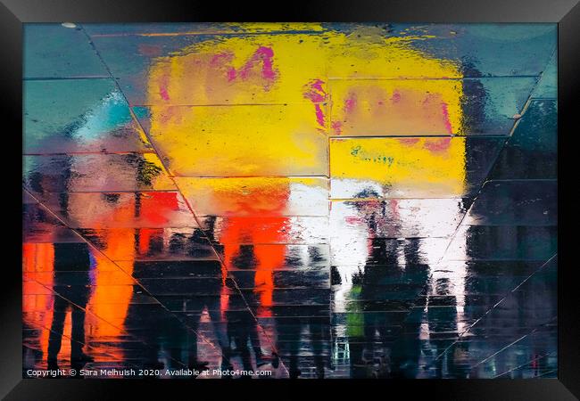 Neon reflections in wet pavement at night Framed Print by Sara Melhuish