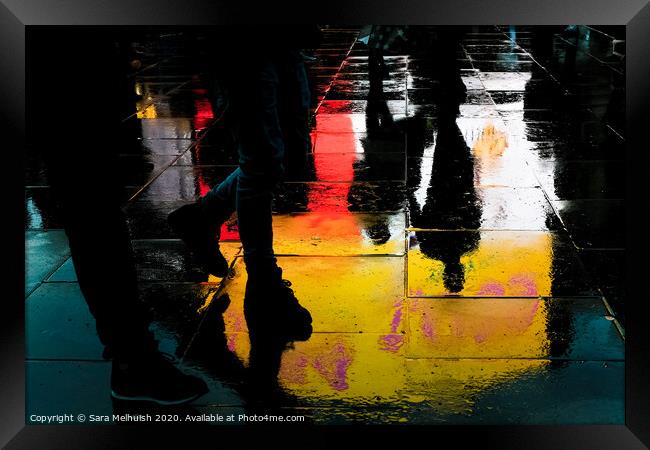 Feet and reflections in wet pavement Framed Print by Sara Melhuish