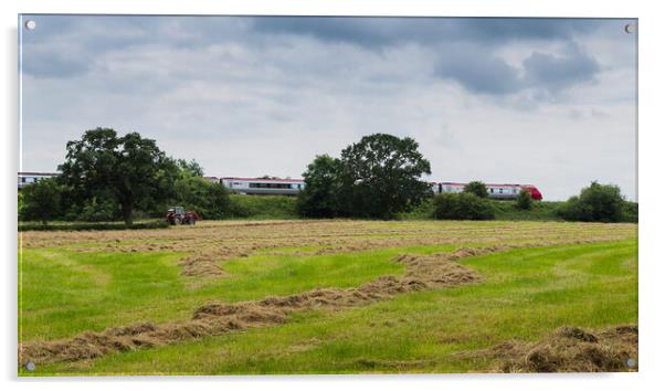 A Virgin train passes a tractor on a field Acrylic by Jason Wells
