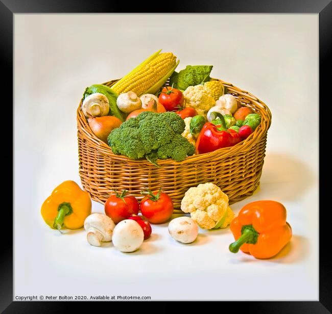 Studio still life of a basket of fresh vegetables on a white background. Framed Print by Peter Bolton