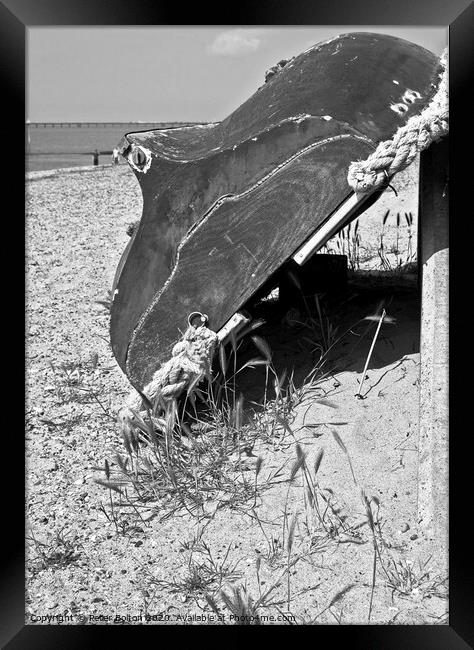 A wooden dinghy propped up against a seawall at Thorpe Bay, Essex, UK.  Framed Print by Peter Bolton