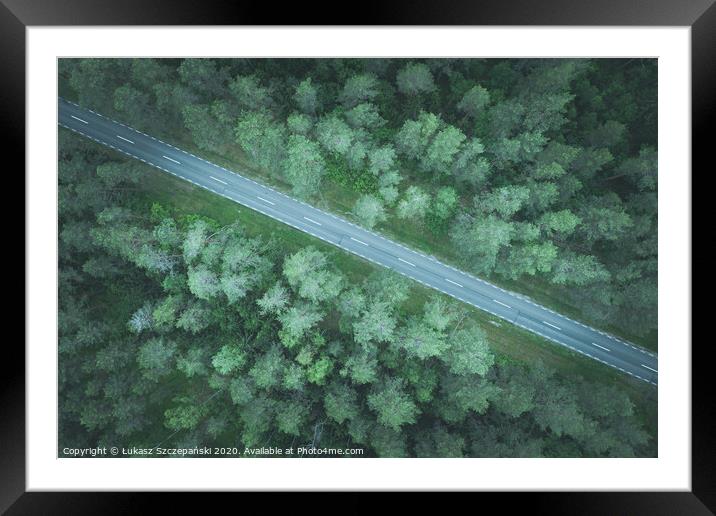 A road through green pine forest Framed Mounted Print by Łukasz Szczepański