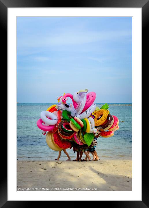 People hiding behind beach toys Framed Mounted Print by Sara Melhuish