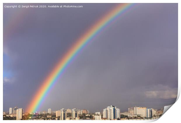 A large bright rainbow in the gray sky above the city after the last thunderstorm. Print by Sergii Petruk
