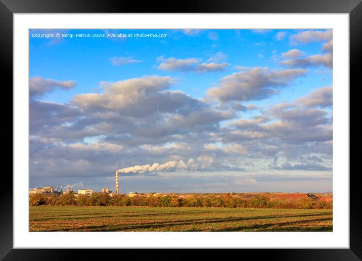 Rural autumn landscape, bright morning sunshine illuminate the agricultural field, the production complex on the horizon and a high cloudy sky. Framed Mounted Print by Sergii Petruk