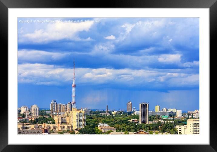 TV tower and residential areas of Kyiv at noon against the backdrop of a stormy blue summer sky. Framed Mounted Print by Sergii Petruk