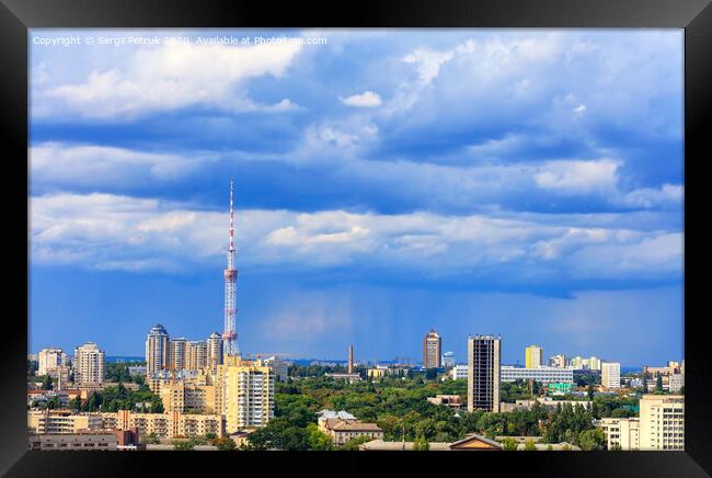 TV tower and residential areas of Kyiv at noon against the backdrop of a stormy blue summer sky. Framed Print by Sergii Petruk
