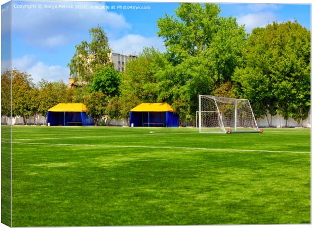 Green lawn of a soccer field with gates and tents for teams players. Canvas Print by Sergii Petruk