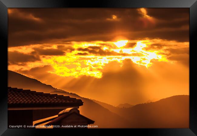 a golden sunset of threatening clouds  Framed Print by susanna mattioda