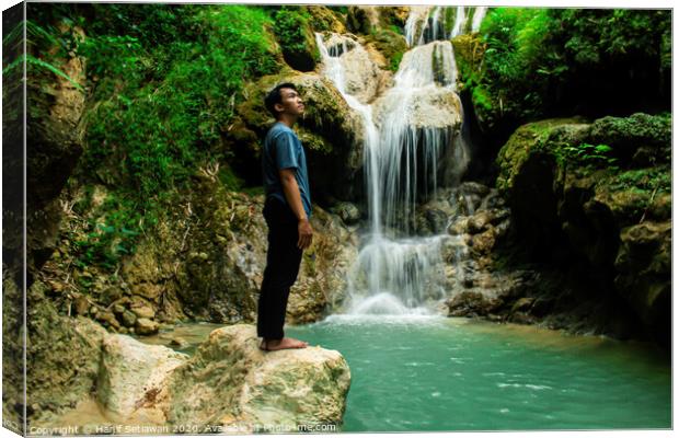 Young man enjoys the waterfall Mudal Canvas Print by Hanif Setiawan